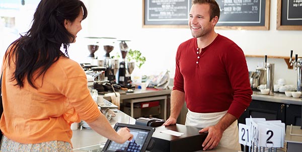 Customer Paying In Coffee Shop Using Touchscreen
