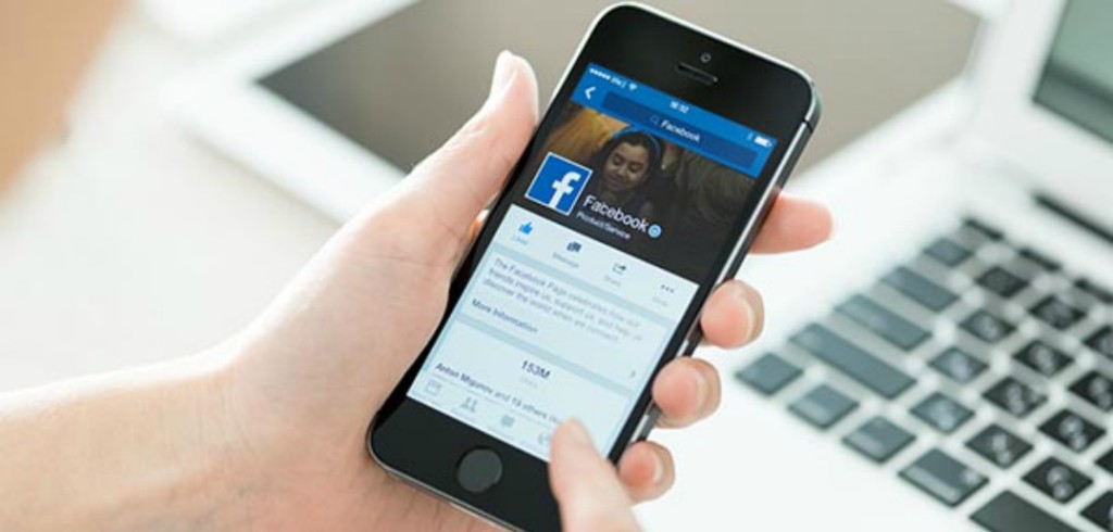 Person holding a brand new Apple iPhone 5S with Facebook profile on the screen. Facebook is a social media online service for microblogging and networking founded in February 4 2004.