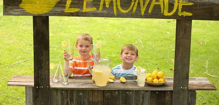 dos niños en un puesto de limonadas