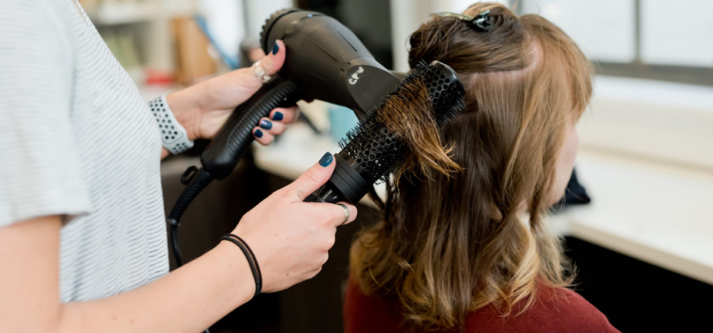 estilista haciendo un corte de pelo a una clienta