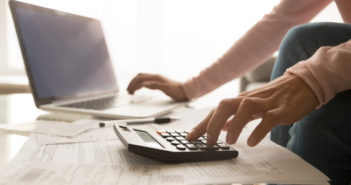 Consejos para controlar las finanzas durante una crisis hombre usando una calculadora para controlar gastos