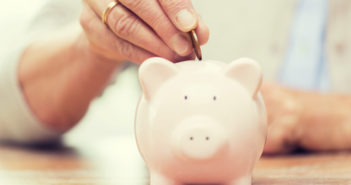 ¿El plan 401k de su empresa hace lo mejor para los empleados? persona de edad avanzada poniendo dinero en una alcancía