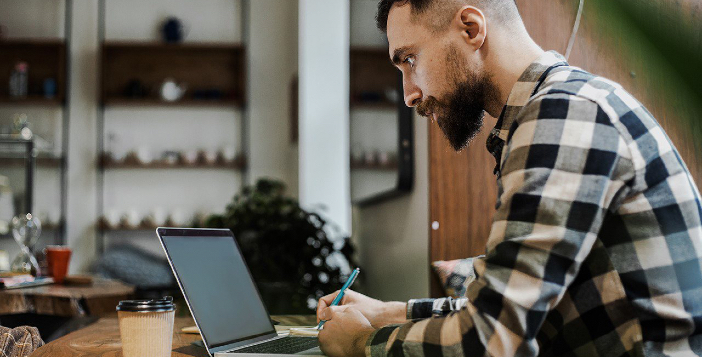 Hombre con barba trabajando en su laptop