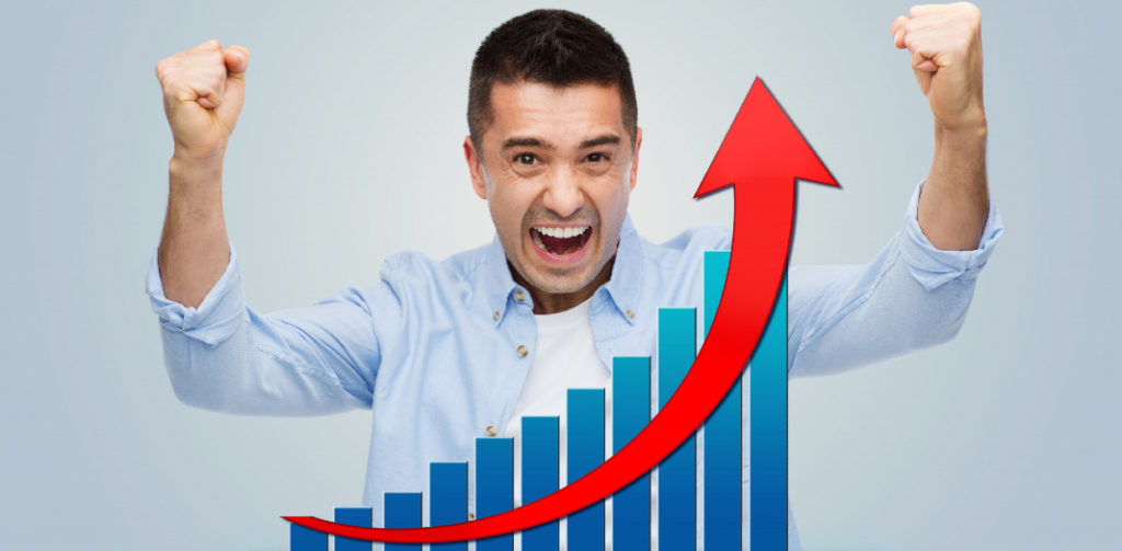 Hombre celebrando junto a una gráfica de ventas