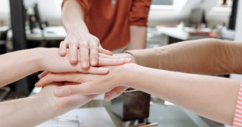 Consejos para transformar a un micromanager en un líder de servicio Personas uniendo sus manos para trabajar en equipo