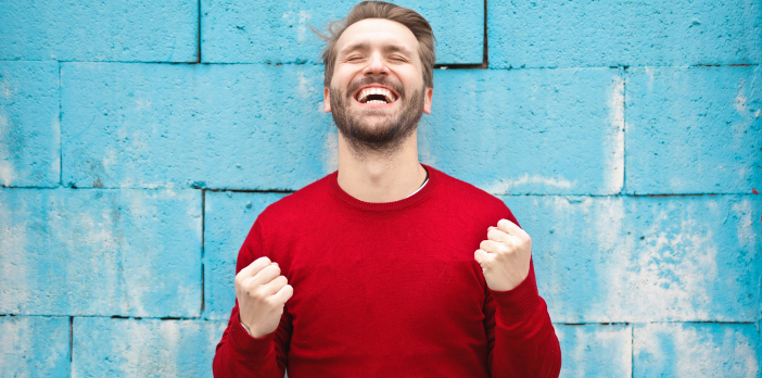 Hombre feliz con suéter rojo en una barda azul